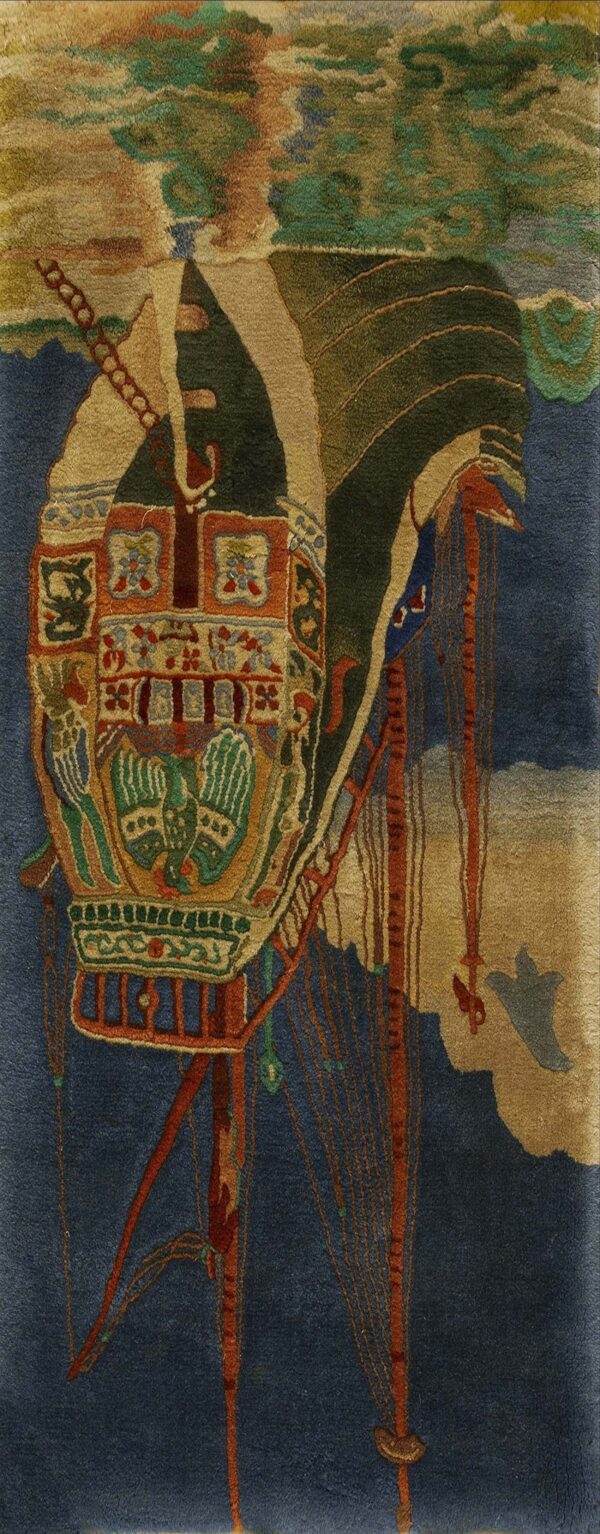 Pictorial rug detail featuring a complex structure in green, rust, and tan against a deep blue background.