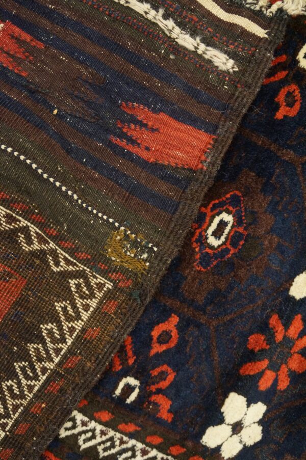 Detail of two rugs showing a dark striped flat weave and a navy, red, and cream high-pile pattern.