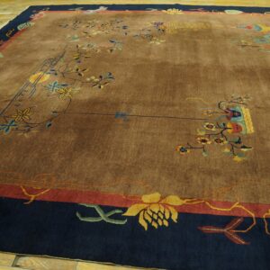 Brown rug featuring colorful scattered vines and flowers within a wide navy and red decorative border on wood floors.