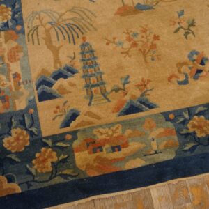 Tan rug with blue border and detailed scenic pattern featuring pagodas and trees on wood floors.