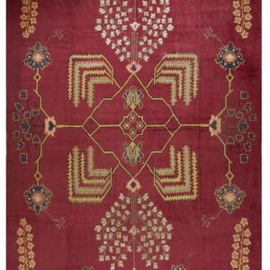Deep burgundy rug featuring a symmetrical pattern of stylized trees, geometric elements, and floral medallions.