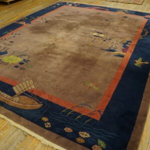 Brown and navy scenic rug featuring boats and birds, framed by an orange border on light wood floors.