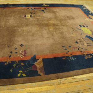 Low-pile brown rug with colorful floral and bird motifs, featuring a dark blue and coral border on wood planks.