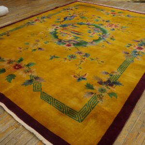 Saffron rug with colorful floral and bird patterns and a geometric green border on wood flooring.