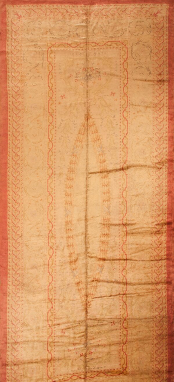 Vertical beige rug with faded central designs and a prominent border of red heart shapes.