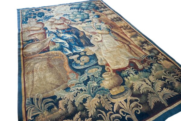 Flat rug featuring a detailed, classical scene of figures playing music amid blue and beige foliage.