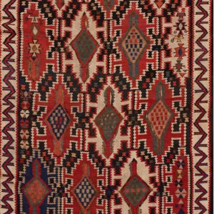Geometric flatweave rug featuring stepped medallions and interlocking patterns in red, black, cream, and blue.