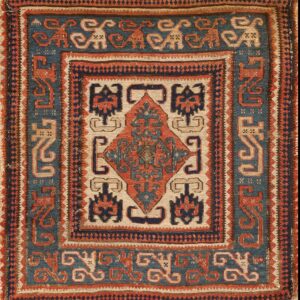 Low-pile geometric rug in indigo blue, rust red, and beige, featuring repeating stylized animal motifs.
