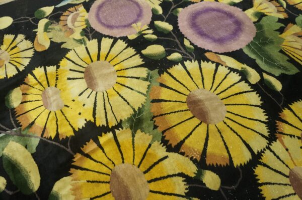 Black rug featuring large scale yellow sunflowers and light purple flowers with green foliage.