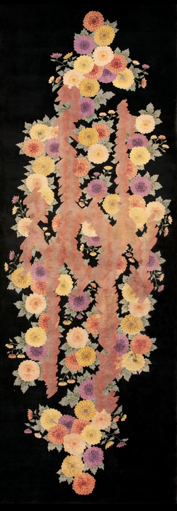 Black rug featuring bright yellow, purple, and peach flowers bordering a tan and red central design.