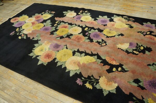 Floral rug featuring yellow, purple, and coral blossoms on a black field with a textured, salmon-colored zigzag design.