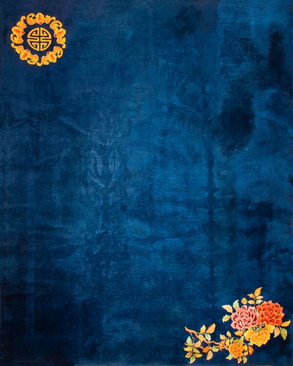 Dark blue rug with subtle texture, featuring gold corner iconography and bright orange and yellow flowers.