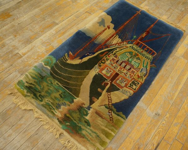 Deep blue rug with a striking colorful ship design and green waves rests on worn wood flooring.