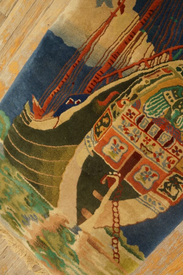 Medium pile rug featuring a stylized blue and red boat scene and colorful geometric accents on wood flooring.