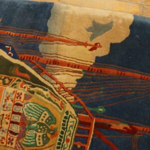 High-pile rug with abstract dark blue and orange forms, surrounded by green and multicolored geometric motifs on wood floor.