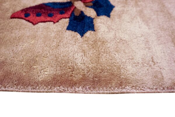 The plush edge of a beige rug displays stylized motifs in vibrant blue and deep red.