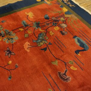 Rust field rug with stylized blue birds, colorful floral vines, and a contrasting navy blue border.