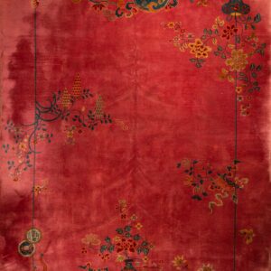 Deep red rug with complex floral and vase designs in teal and gold around a solid main field.