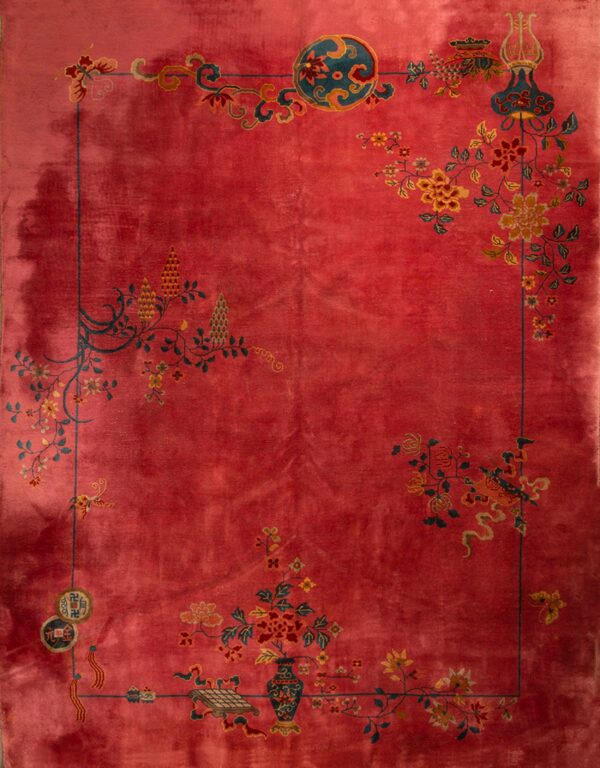 Deep red rug with complex floral and vase designs in teal and gold around a solid main field.