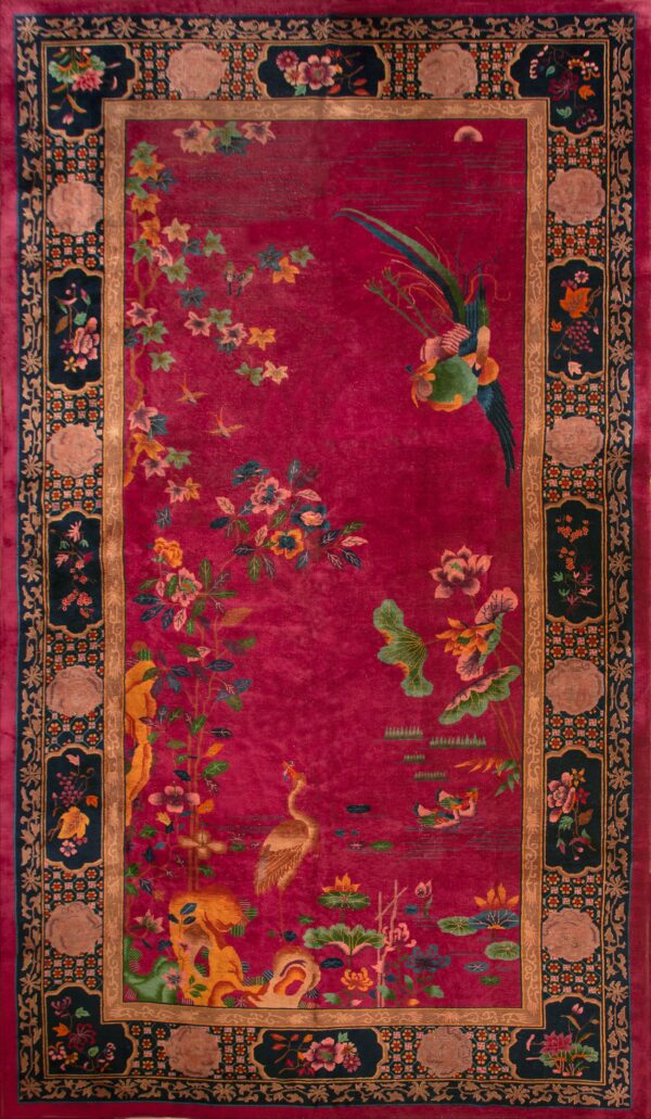 Tall red rug featuring birds and flowers surrounded by a detailed navy and gold frame.
