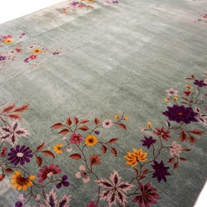 Striated sage green rug with scattered floral motifs in purple, yellow, and pink on a white background.
