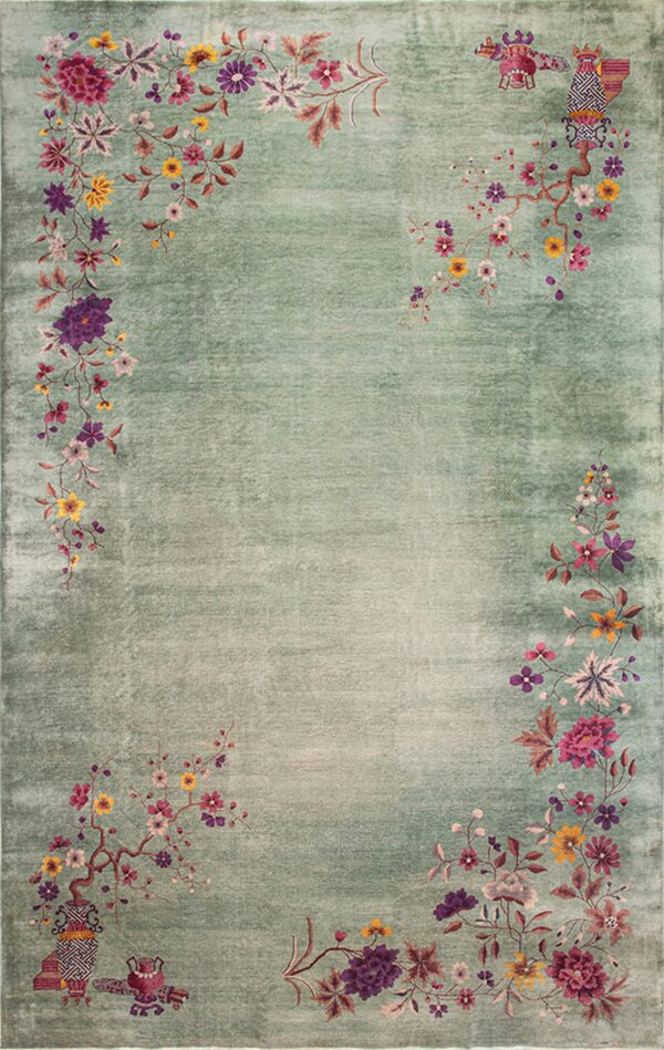 Sage green rug with low pile and decorative floral borders in magenta, purple, and gold colors.