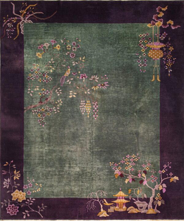 Deep moss green rug with a wide purple border and detailed floral chinoiserie patterns.