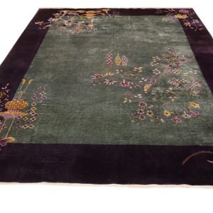 Rectangular rug featuring a sage green field framed by a wide deep purple border with floral and bird designs.