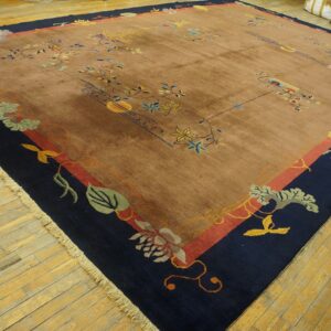 Low-pile brown rug featuring colorful floral designs and a dark blue border on yellow wood floors.
