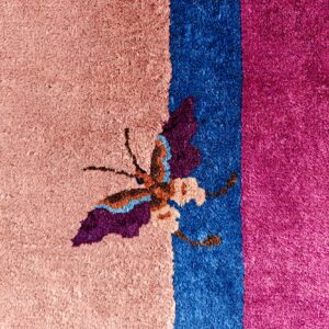 High-pile rug featuring a colorful butterfly pattern across pink, bright blue, and fuchsia color blocks.