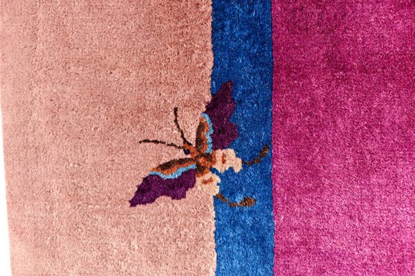 High-pile rug featuring a colorful butterfly pattern across pink, bright blue, and fuchsia color blocks.