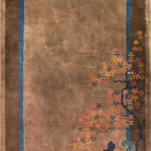 Shaded brown rug featuring a blue inner border and a colorful floral landscape motif in the corner.