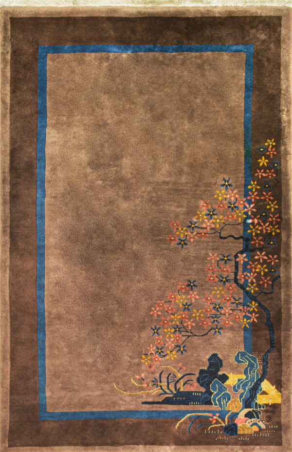 Shaded brown rug featuring a blue inner border and a colorful floral landscape motif in the corner.