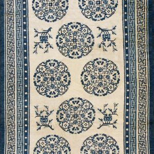 A blue and ivory runner rug with repeating circular medallions and elaborate fretwork borders.