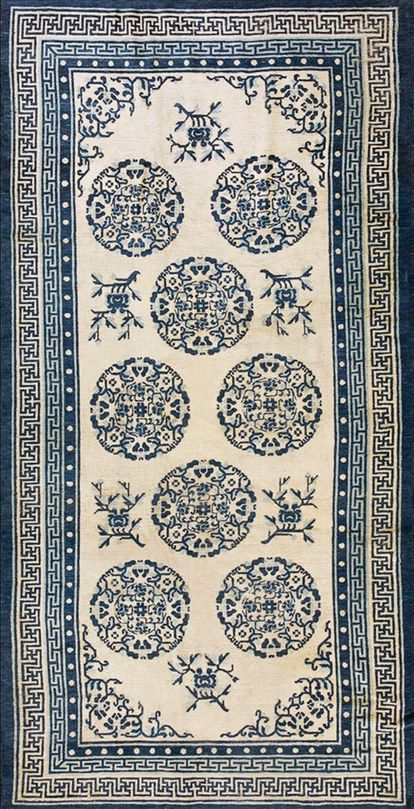 A blue and ivory runner rug with repeating circular medallions and elaborate fretwork borders.