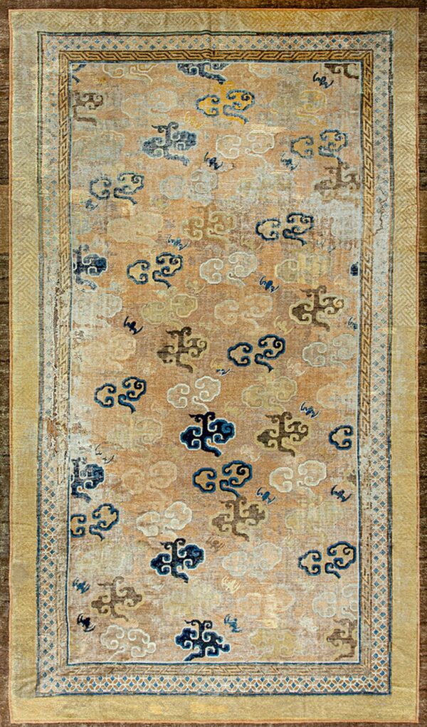 Tan and beige low-pile rug featuring scattered blue and gold stylized cloud patterns and complex gold borders.
