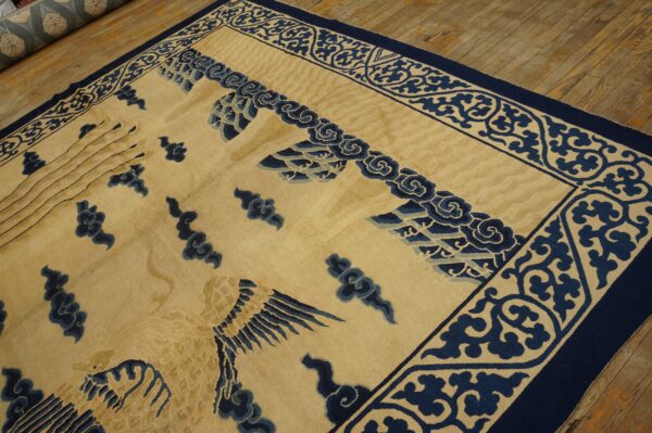 Cream rug with a blue decorative border and avian pattern laid over rustic wood planks.