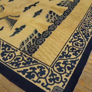 Beige and navy rug featuring a bird and cloud motifs, detailed border, resting on wood planks.