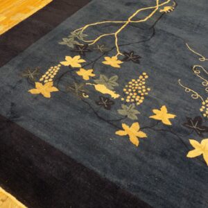 Deep blue rug with gold and green grapevine motifs on light wood plank flooring.