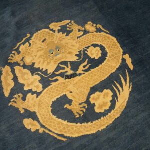 Dark navy rug with a circular gold and tan dragon design motif in the center.