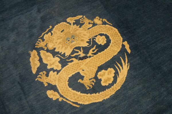 Dark navy rug with a circular gold and tan dragon design motif in the center.
