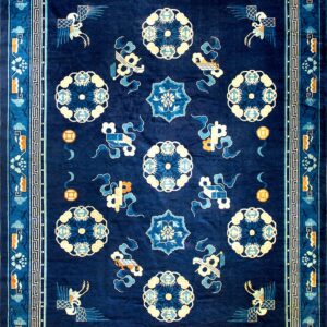 Dark blue rug with a geometric border and central field of medallions, birds, and orange accents.