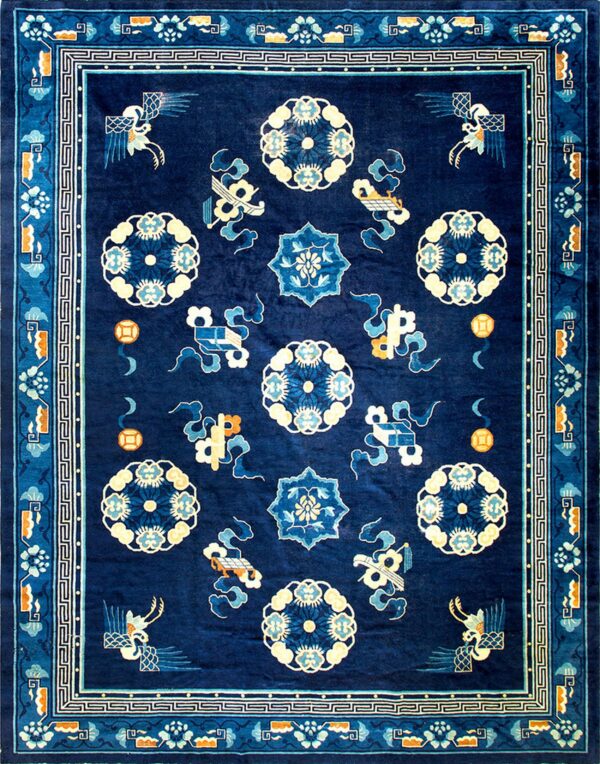 Dark blue rug with a geometric border and central field of medallions, birds, and orange accents.