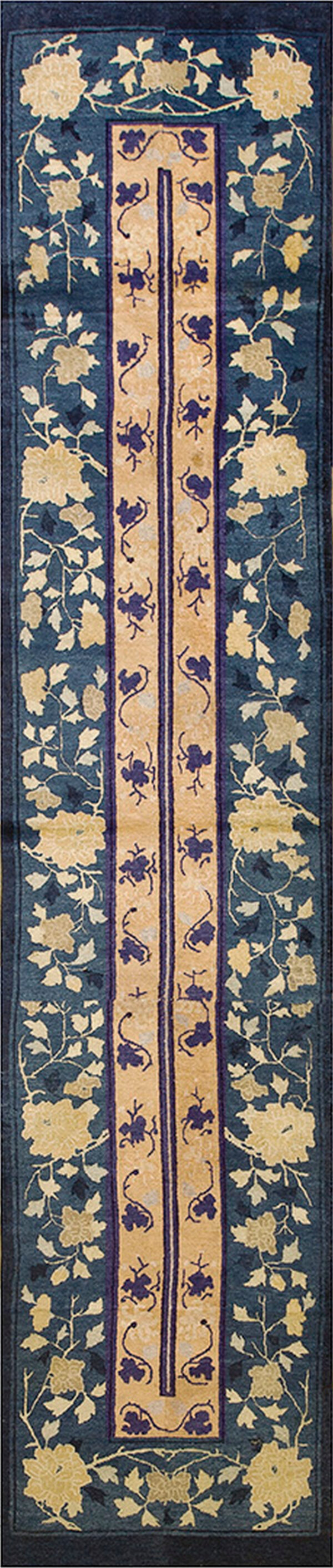 Dark blue runner rug with intricate gold floral vines flanking a beige center stripe.