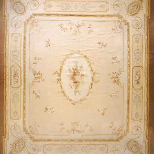 Square rug featuring a pale cream field, pink floral motifs, and detailed gold and tan architectural borders.