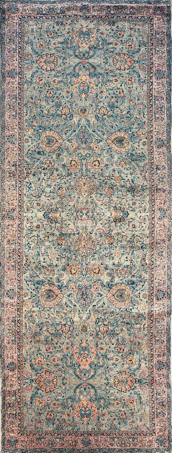 Long runner rug with a dense traditional floral pattern in muted turquoise, rose, and beige.