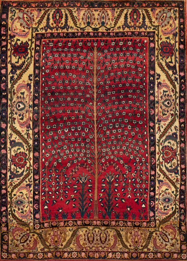 Red rug featuring a central tree of life pattern framed by intricate multicolored floral borders on a gold ground.