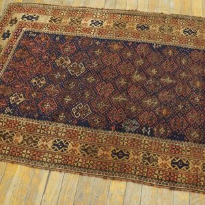 Geometric patterned runner rug in navy, tan, and red on distressed yellow-toned hardwood planks.