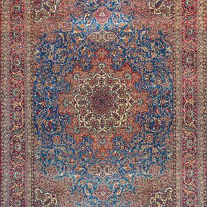 Ornate traditional rug featuring a deep blue field, red border, and complex floral medallion design.