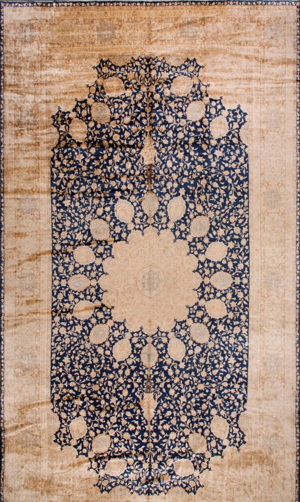 Distressed rug with a central beige medallion, surrounded by a navy blue floral mihrab design and beige spandrels.